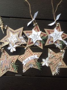 six christmas star ornaments hanging from strings on a wooden table with the words god help written on them