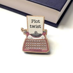 Do you like a plot twist? This typewriter shaped wooden pin badge is perfect for readers and writers alike! Perfect for any bookworm or lover of the written word, this pin would look perfect on a jacket lapel or bag. This 38mm mm pin is laser cut from 4mm Maple veneered MDF with a little silver butterfly fastening on the back. Eco friendly - Our wooden pin badges are made in the UK and use 20 to 24 times less energy to produce than enamel pin badges! Size: 3.8cm x 3.8cm ------------------------- Gift For Book Lover, Book Pins, Literary Gifts, Enamel Pin Badge, Plot Twist, Silver Butterfly, Gifts For Readers, Funny Pins, Typewriter