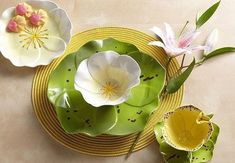 three plates with flower decorations on them sitting on a table top next to each other