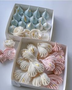 two white boxes filled with different colored seashells