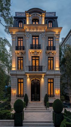 a large white building with lots of windows and lights on it's front entrance