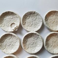 six white ceramic dishes with designs on them