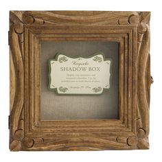 the shadow box is made from wood and has an ornate frame with a sign on it