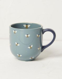 a blue coffee cup with bees on it