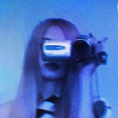 a woman with long white hair is looking at the camera and has her reflection in the mirror