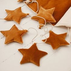 some brown stars hanging from a string on a white table with a pillow and other items