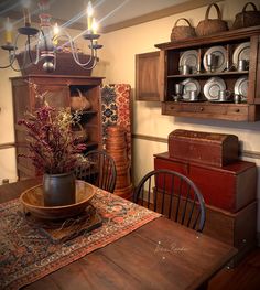 a dining room table with a bowl on top of it and some candles in the middle