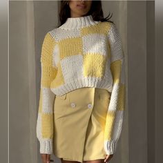 a woman is wearing a yellow and white knitted sweater with high - waisted shorts