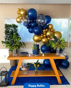 a table topped with balloons and potted plants