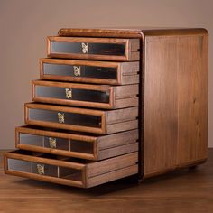 a wooden cabinet with five drawers on top of it and one drawer open to show the contents