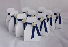 six white vases with blue ribbons and flowers on them are arranged in a row