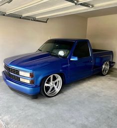 a blue pick up truck parked in a garage