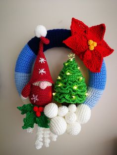 three crocheted christmas wreaths on top of each other with decorations around them