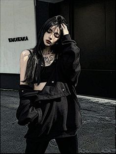 a woman standing on the street with her hand in her hair and wearing black clothing