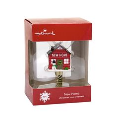 a christmas ornament in a box with a red house on it's side