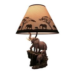 an elephant lamp on a table next to a light shade with the image of elephants