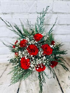 a bouquet of red roses and baby's breath