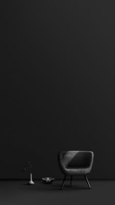 a black and white photo of a chair next to a table with a plant on it