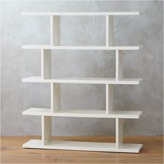 a white book shelf sitting on top of a wooden floor