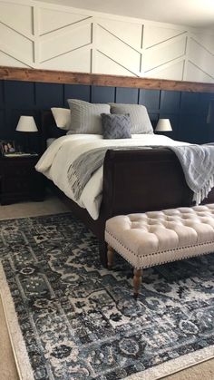 a large bed sitting on top of a blue and white rug next to a wooden headboard