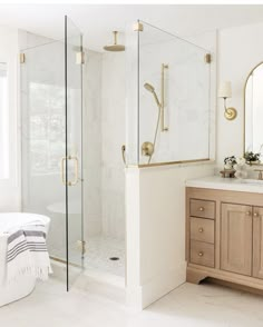 a bathroom with marble counter tops and gold fixtures, including a walk - in shower