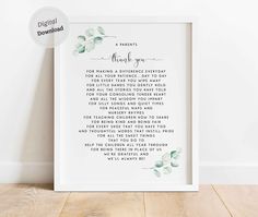 a white framed print with the words and flowers on it, in front of a wooden floor