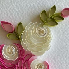 paper flowers are arranged on a white surface