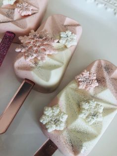 three pink and white soaps on top of each other next to a purple spatula