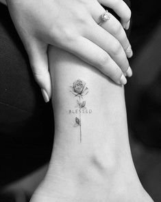 a woman's foot with a rose tattoo on it