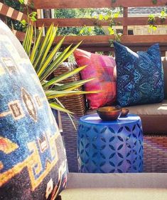 colorful cushions and pillows on a bench in the sun