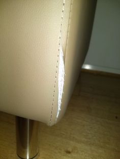 a close up of a white leather chair with stitching on the armrests