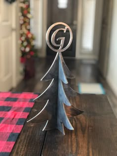 a metal christmas tree sitting on top of a wooden table