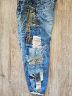 an old pair of jeans with patchwork on the back and sides, sitting on a wooden floor