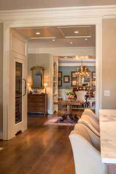 an open living room and dining room with wood flooring, white walls and furniture