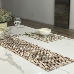 two place mats on top of a table with wine glasses and succulents