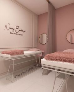 a room with two beds and mirrors on the wall, one bed has a pink rug on it