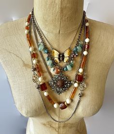 This is an instant, exotic bohemian collection! Let your bohemian soul sing with this layered set of 3 necklaces.  Wear them together or on their own to create different looks. The necklaces are a combination of materials, metals, patterns and finishes for an amazing assortment! Colors of turquoise,  brown, aqua and silver metal, etc.   (1) Designer vintage necklace from the Crown Trifari collection.  This is done out of lucite.  I love the color combination of honey brown, cream, etc.  It has the Crown Trifari hang tag. 24" long, great condition.   (2) Longest necklace is 52".  From the 70s, it is a long silver tone chain that is accented with ball and open cut links.  It has a clasp so you can also double it over.  Great condition. (3) Pretty earth toned enamel butterfly!  She is done in Chunky Stone Necklace, Butterfly Boho, Enamel Butterfly, Boho Turquoise, Bohemian Soul, Vintage Crown, Silver Collection, Crown Trifari, Shades Of Teal