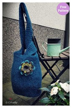 a blue purse sitting on top of a table next to a chair and potted plant