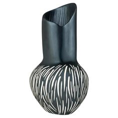 a black and white striped vase is shown on a white background with the image of an animal print pattern