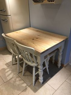 a kitchen table with chairs around it in the middle of a tile floored room