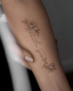 a woman's arm with a flower tattoo on it