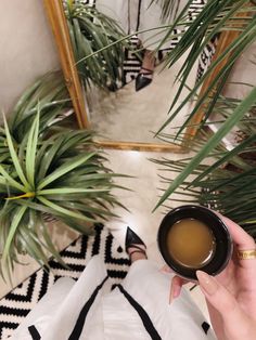 a person holding a cup of coffee in their hand