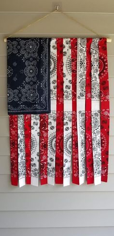 an american flag made out of bandannas hanging from a hook on a wall