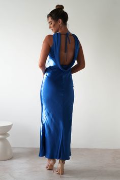 a woman in a blue dress looking back