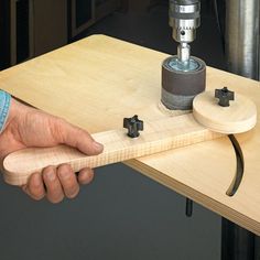 a person holding a piece of wood with a drill in it's hand while working on a project