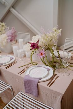 the table is set with white and pink flowers