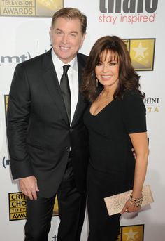 a man and woman standing next to each other on the red carpet at an event