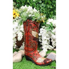 a pair of red boots sitting on top of green grass next to white and yellow flowers