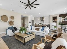 a living room filled with furniture and a ceiling fan