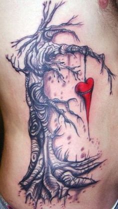 a woman's lower back with a tree and heart tattoo on her stomach,